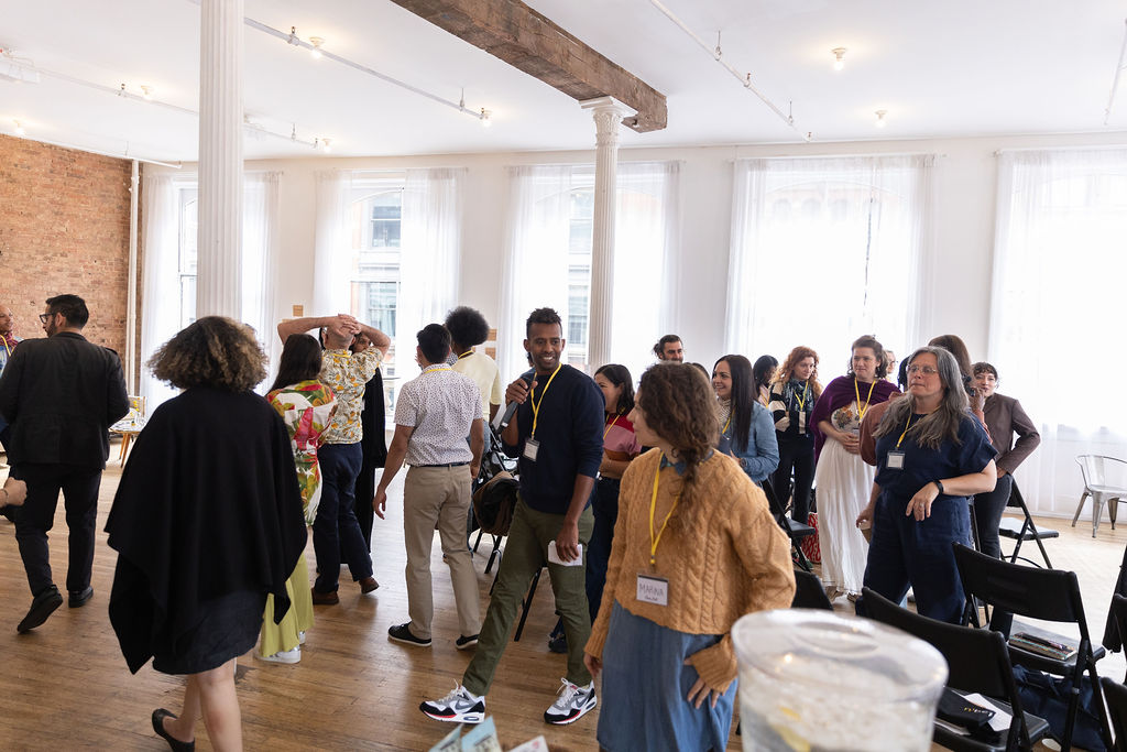 Educators and family-serving practitioners standing and talking in a bright loft room between sessions.